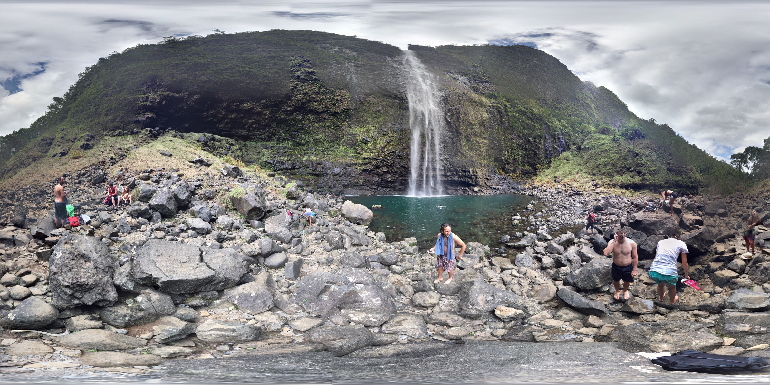 A 360 degree panarama showing the falls, people in bathing suits, and lots of rocks.