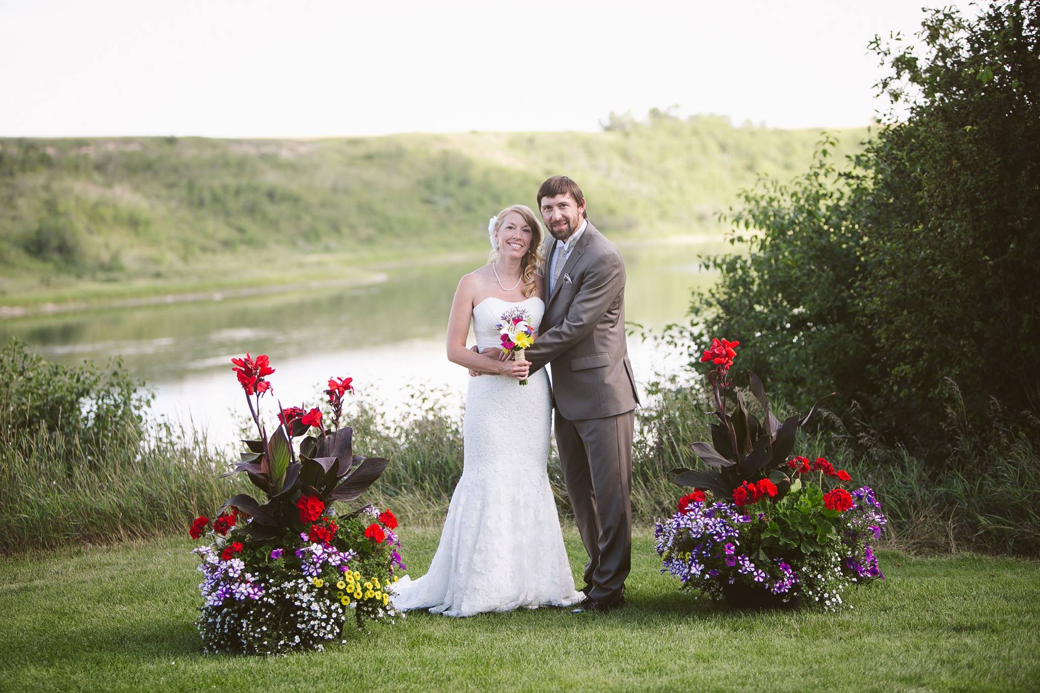 Bride Andrea and Groom Jeff standing with river in background